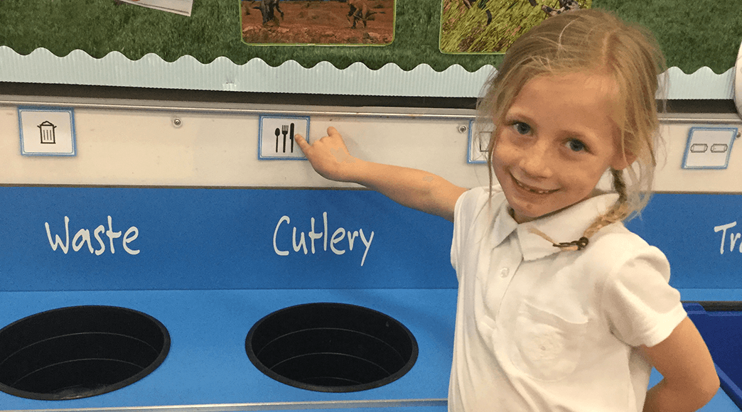 Young girl poimtint at Makaton symbol for cutlery