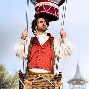 A man standing in a prop hot air balloon