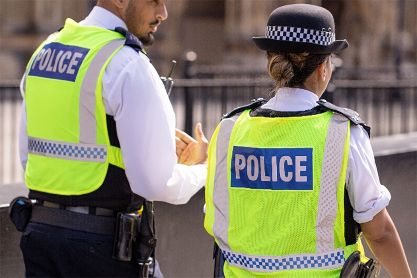 A policeman and a policewoman walking down the street